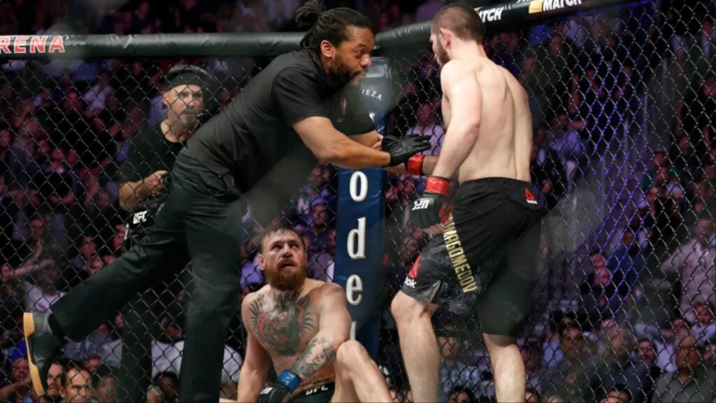 Referee Herb Dean stops the UFC fight, separating Khabib Nurmagomedov from a defeated Conor McGregor on the canvas.