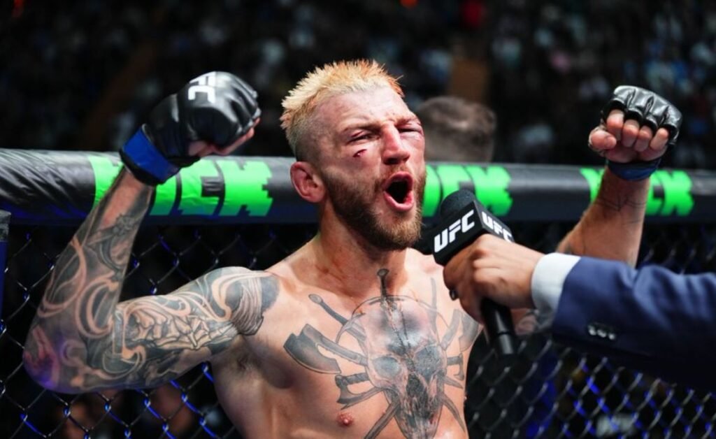 El luchador de UFC Dan Hooker celebra su victoria gritando con el rostro herido y los puños en alto en el octágono.