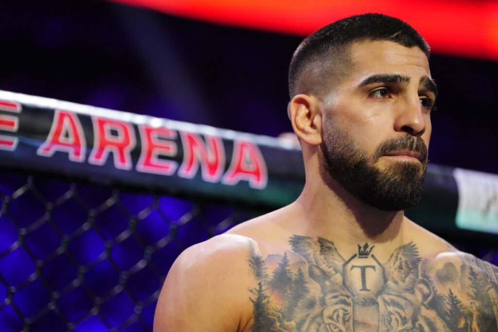 El luchador de UFC Ilia Topuria con semblante serio en el octágono, luciendo su tatuaje en el pecho.