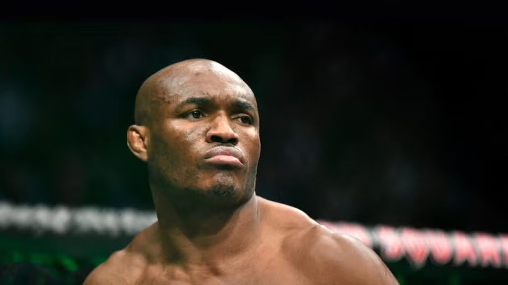 A close-up of UFC fighter Kamaru Usman with a serious, focused expression inside the fighting ring.