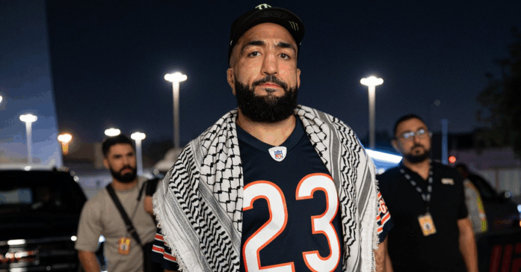 Belal Muhammad posa de noche con una kufiya sobre una camiseta de la NFL con el número 23.