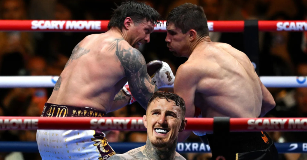 Intenso combate de boxeo: dos luchadores en el ring, uno tatuado. Un tercer boxeador sonríe con protector bucal.