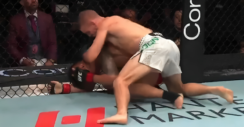 Cody Haddon (shorts blancos) domina a Aoriqileng en el suelo del octágono de UFC, preparándose para golpear.