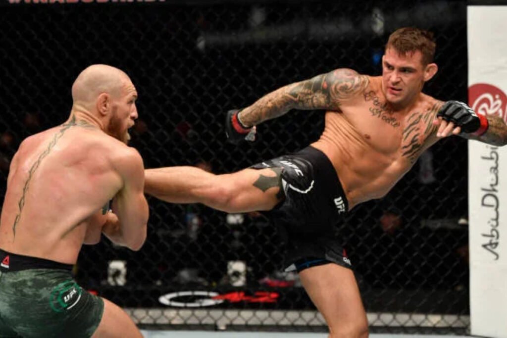 Dustin Poirier (negro) lanza una patada a Conor McGregor (verde) en el octágono durante un combate de UFC.
