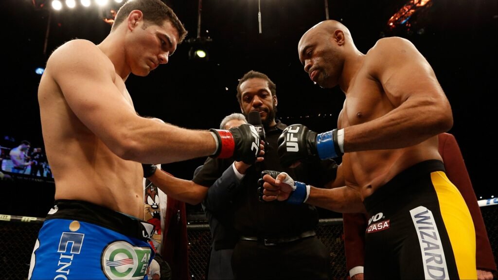 Luchadores de MMA concentrados, cara a cara con el árbitro de UFC en el octógono antes del combate.