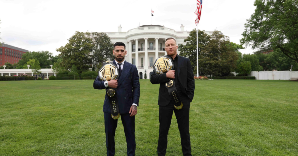 Dos luchadores de UFC, Yair Rodríguez y Georges St-Pierre, posan con cinturones de campeón frente a la Casa Blanca.
