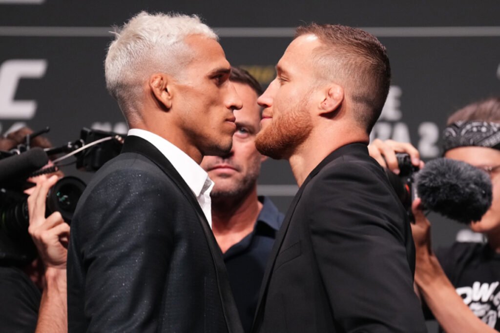 Careo intenso de Charles Oliveira y Justin Gaethje en el pesaje de UFC 274, ambos con trajes negros.