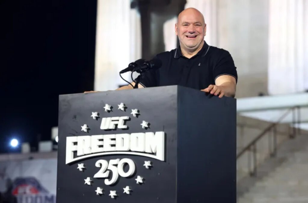 Dana White sonríe en el podio de UFC FREEDOM 250, decorado con estrellas, durante una conferencia de prensa.