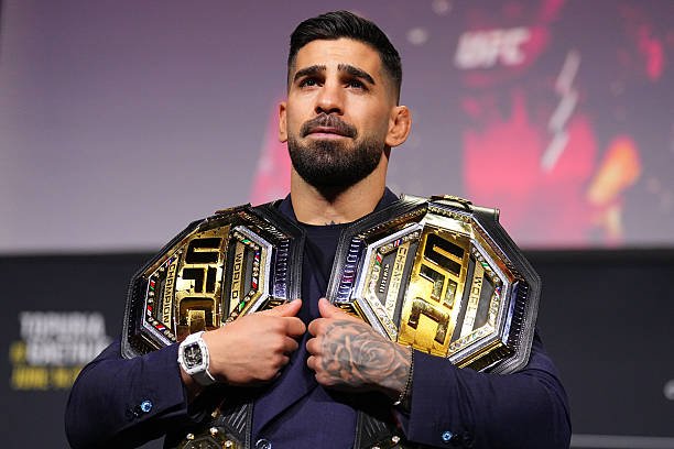 Ilia Topuria, campeón de UFC, exhibe orgulloso sus dos cinturones dorados de artes marciales mixtas.