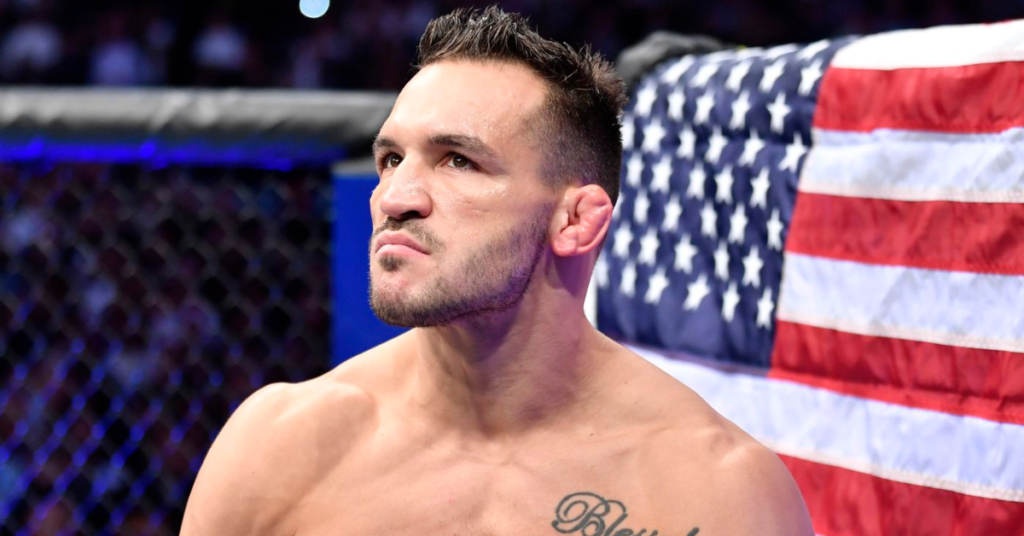 Michael Chandler, luchador de UFC, con expresión seria y cicatrices faciales, ante una bandera de EE. UU. en el octágono.