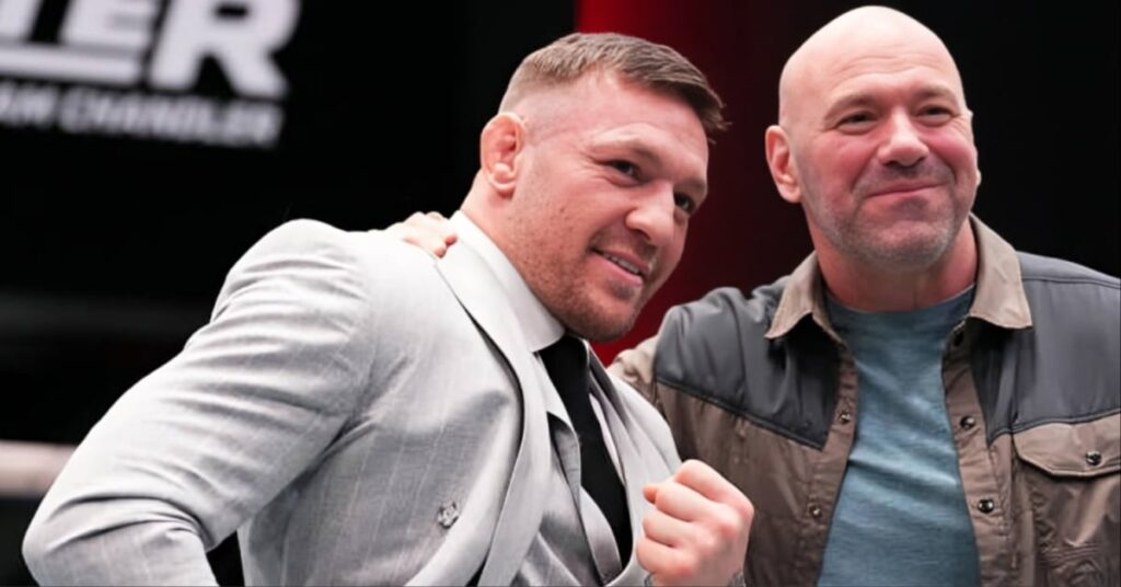 El luchador Conor McGregor, en traje claro, y el promotor Dana White, en camisa, posan sonrientes en un evento de MMA.