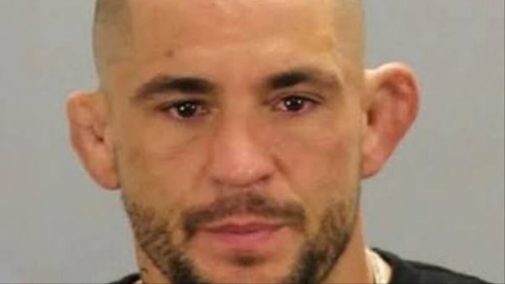 Primer plano de hombre con barba, pelo rapado y orejas de coliflor. Su mirada es directa y seria.