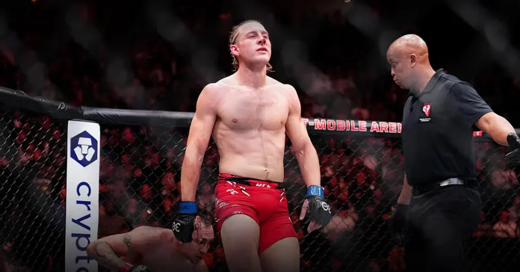 Paddy Pimblett, luchador de UFC, celebra victoria en el octágono con árbitro. Rival KO en el suelo. Logos Crypto visibles.