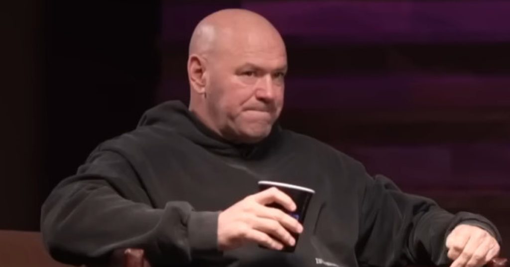 Dana White, presidente de UFC, en sudadera negra, sostiene un vaso, con expresión pensativa.