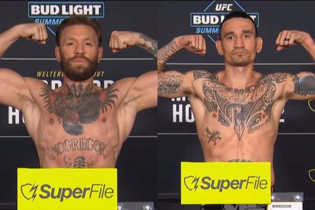 Conor McGregor y Max Holloway en pesaje de UFC. Los luchadores flexionan los bíceps, mostrando sus elaborados tatuajes.