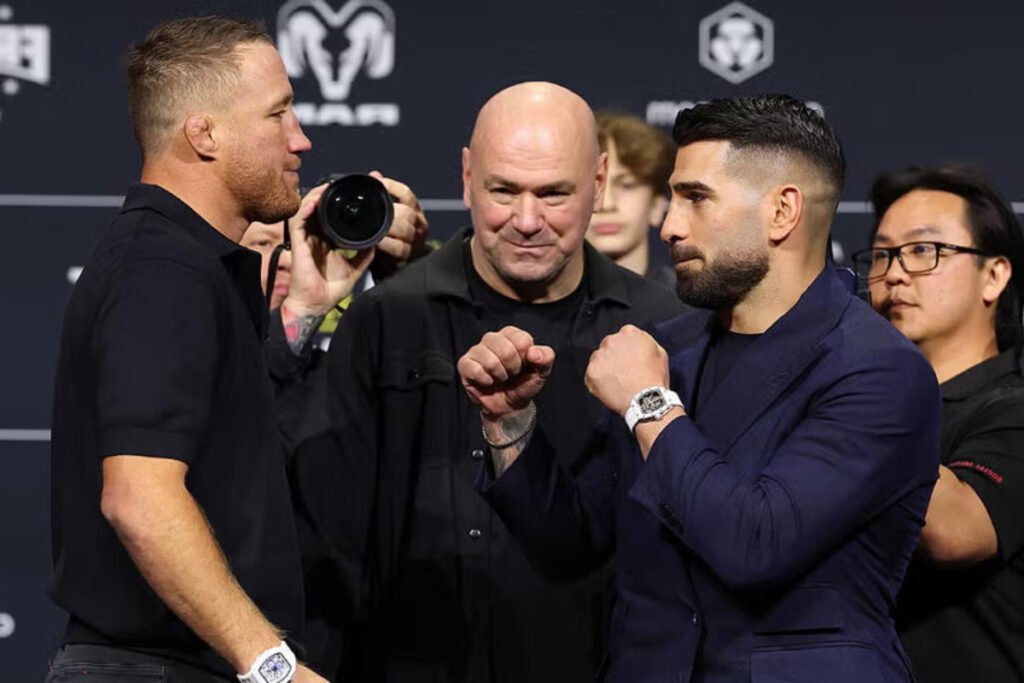 Justin Gaethje e Ilia Topuria en un intenso cara a cara UFC, con Dana White sonriente entre ellos. Ambiente de pesaje.