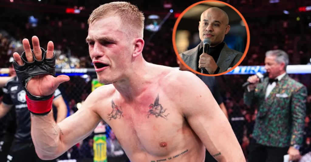 Luchador de MMA con guante y tatuajes en el ring tras un combate. Un anunciador con micrófono en recuadro; otro al fondo.