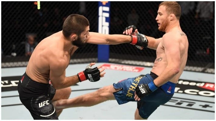 Khabib lanza un puñetazo en combate UFC contra Gaethje, quien le conecta una patada al cuerpo en el Octágono.