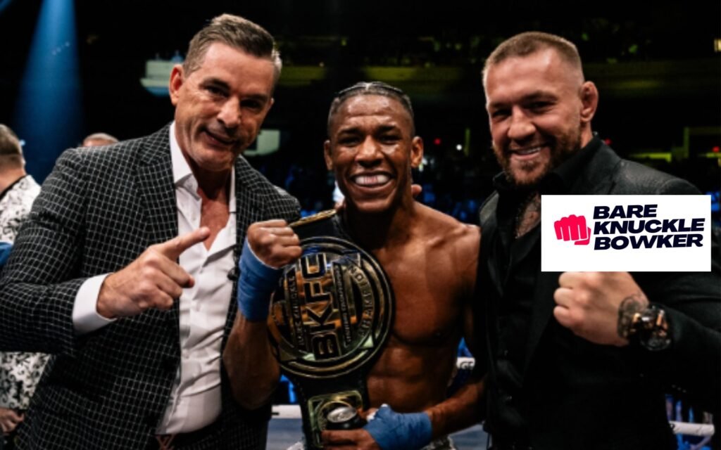 Conor McGregor, David Feldman y el campeón de BKFC celebran con el cinturón. Sonrisas tras un evento de lucha a puño descubierto.