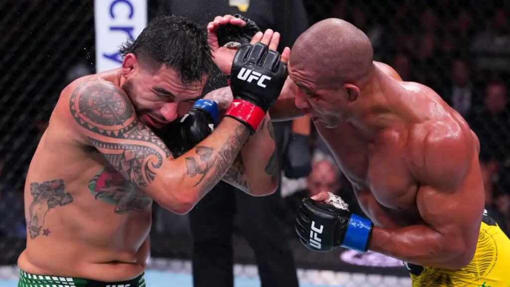 Gregory Rodrigues golpea a Anthony Hernandez en un combate de UFC. Intensa acción de los peleadores en el octágono, sudorosos y tatuados.
