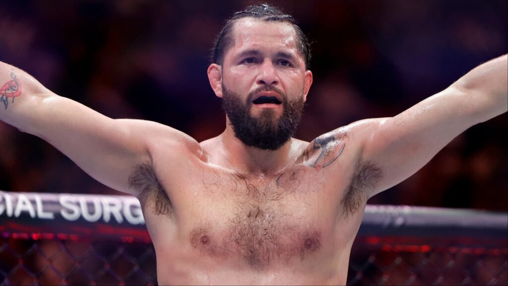 Jorge Masvidal, luchador de MMA sudoroso y barbudo, brazos en alto en el ring tras el combate.