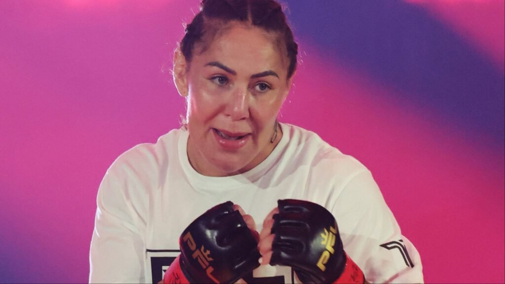 Luchadora de MMA con trenzas, guantes PFL, lista para el combate. Camiseta blanca sobre fondo rosa y púrpura.