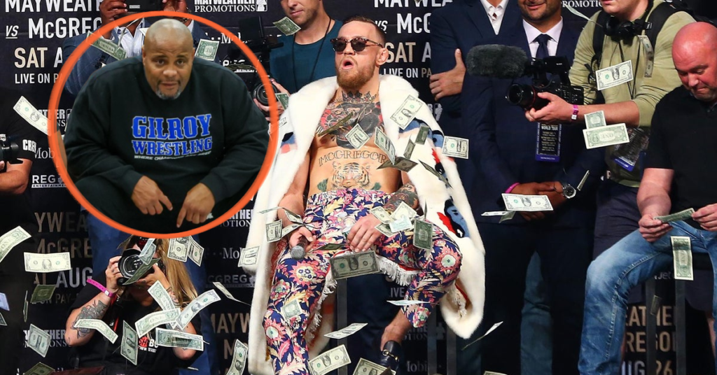 Conor McGregor con abrigo de piel y dinero cayendo en la rueda de prensa Mayweather vs McGregor. Con Daniel Cormier y Dana White.