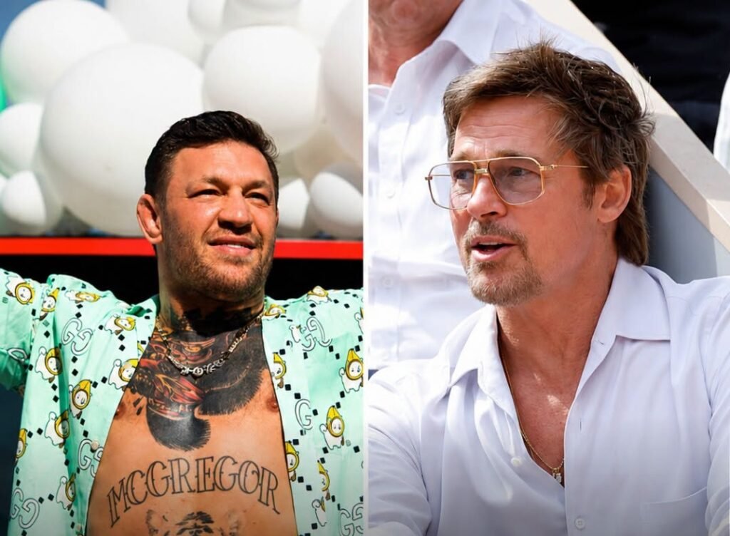 Conor McGregor, con camisa abierta y tatuajes, junto a Brad Pitt, con gafas de sol y barba, ambos sonriendo.