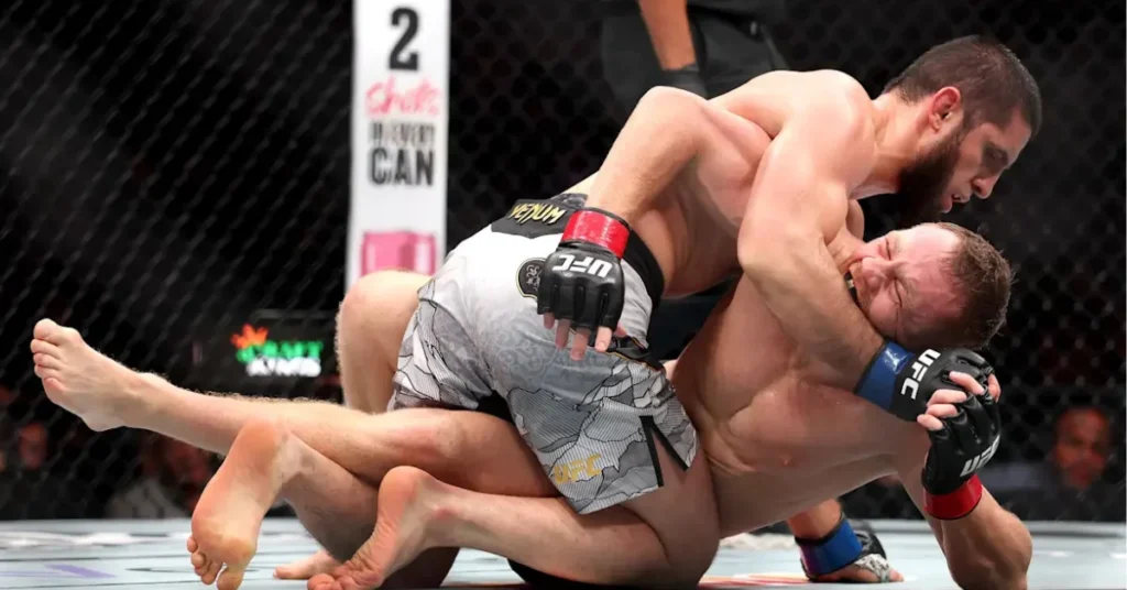 Combate UFC: luchador barbudo somete a su rival con un estrangulamiento. Intensa acción de MMA en el octágono.